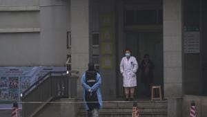 Hospital staff stand outside the emergency entrance of Wuhan Medical Treatment Center, where some infected with a new virus are being treated.(AP Photo) Hospital staff stand outside the emergency entrance of Wuhan Medical Treatment Center, where some infected with a new virus are being treated.(AP Photo)