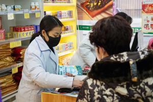Staff sell masks at a Yifeng Pharmacy in Wuhan.(AP) Staff sell masks at a Yifeng Pharmacy in Wuhan.(AP)
