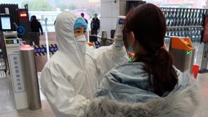 A worker in protective suits checks the temperature of a passenger arriving at the Xianning North Station on the eve of the Chinese Lunar New Year celebrations, in Xianning, a city bordering Wuhan to the north, in Hubei province, China January 24, 2020.(Reuters) A worker in protective suits checks the temperature of a passenger arriving at the Xianning North Station on the eve of the Chinese Lunar New Year celebrations, in Xianning, a city bordering Wuhan to the north, in Hubei province, China January 24, 2020.(Reuters)