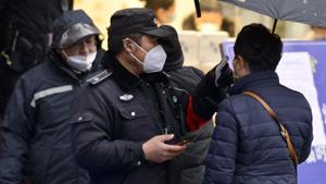 A policeman wearing a face mask takes a tourist's temperature at the Qinhuai scenic zone in Nanjing in eastern China's Jiangsu province. The virus-hit Chinese city of Wuhan, already on lockdown, has banned most vehicles downtown.(AP PHOTO.) A policeman wearing a face mask takes a tourist's temperature at the Qinhuai scenic zone in Nanjing in eastern China's Jiangsu province. The virus-hit Chinese city of Wuhan, already on lockdown, has banned most vehicles downtown.(AP PHOTO.)
