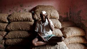 A labourer talks on his mobile phone as he sits on sacks of onions at a wholesale market in Mumbai.(Photo: Reuters) A labourer talks on his mobile phone as he sits on sacks of onions at a wholesale market in Mumbai.(Photo: Reuters)