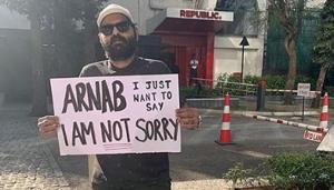 Kunal Kamra poses with a placard outside the offices of Republic TV.