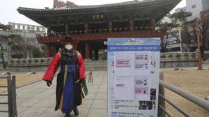 A South Korean Imperial guard wearing a face mask guards near notice warning about a new coronavirus in front of the Bosingak pavilion in Seoul, South Korea.(AP) A South Korean Imperial guard wearing a face mask guards near notice warning about a new coronavirus in front of the Bosingak pavilion in Seoul, South Korea.(AP)