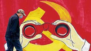 A man walks past a mural showing a modified image of the Chinese Communist Party emblem in Shanghai. A man walks past a mural showing a modified image of the Chinese Communist Party emblem in Shanghai.