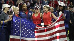 The United States Fed Cup team of Alison Riske, left, captain Kathy Rinaldi, Serena Williams, Sofia Kenin Bethanie Mattek-Sands and Coco Gauff pose with an American flag after beating Latvia in Fed Cup.(AP) The United States Fed Cup team of Alison Riske, left, captain Kathy Rinaldi, Serena Williams, Sofia Kenin Bethanie Mattek-Sands and Coco Gauff pose with an American flag after beating Latvia in Fed Cup.(AP)