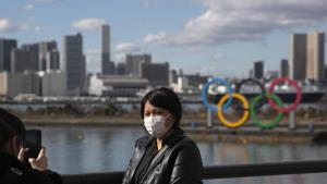 FILE - In this Jan. 29, 2020, file photo, a tourist wearing a mask poses for a photo with the Olympic rings in the background, at Tokyo's Odaiba district. Tokyo Olympic organizers repeated their message at the start of two days of meetings with the IOC: this summer's games will not be cancelled or postponed by the coronavirus spreading neighboring China(AP) FILE - In this Jan. 29, 2020, file photo, a tourist wearing a mask poses for a photo with the Olympic rings in the background, at Tokyo's Odaiba district. Tokyo Olympic organizers repeated their message at the start of two days of meetings with the IOC: this summer's games will not be cancelled or postponed by the coronavirus spreading neighboring China(AP)
