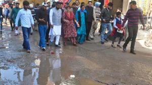Chandigarh mayor Raj Bala Malik (centre) walking through a potholed road at Kishangarh village in Chandigarh on Thursday.(Sant Arora/HT)