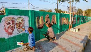 A man gives finishing touches to paintings of US President Donald Trump and Prime Minister Narendra Modi on a wall as part of a beautification along a route that Trump and Modi will be taking during Trump's upcoming visit, in Ahmedabad.(PTI Photo) A man gives finishing touches to paintings of US President Donald Trump and Prime Minister Narendra Modi on a wall as part of a beautification along a route that Trump and Modi will be taking during Trump's upcoming visit, in Ahmedabad.(PTI Photo)