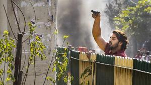 A protester brandishes a pistol during clashes between a group of anti-CAA protesters and supporters of the new citizenship act, at Jafrabad in north-east Delhi, Monday, Feb. 24, 2020.(PTI) A protester brandishes a pistol during clashes between a group of anti-CAA protesters and supporters of the new citizenship act, at Jafrabad in north-east Delhi, Monday, Feb. 24, 2020.(PTI)