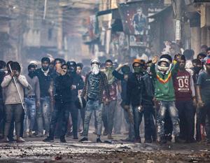 A mob armed with sticks — some of them covering their faces — can be seen during a clash in North-east Delhi on Tuesday.(Photo: PTI) A mob armed with sticks — some of them covering their faces — can be seen during a clash in North-east Delhi on Tuesday.(Photo: PTI)