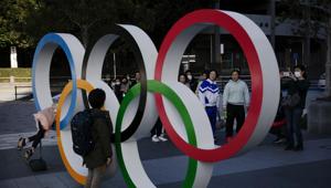 People wait in line to take pictures with the Olympic rings near the New National Stadium(AP) People wait in line to take pictures with the Olympic rings near the New National Stadium(AP)