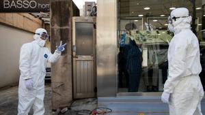 Workers wearing protective suits talk outside a clothing store on Munjeong-dong Rodeo Street in the Songpa district of Seoul, South Korea.(Bloomberg) Workers wearing protective suits talk outside a clothing store on Munjeong-dong Rodeo Street in the Songpa district of Seoul, South Korea.(Bloomberg)