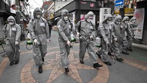 South Korean soldiers wearing protective gear spray disinfectant to help prevent the spread of the Covid-19 coronavirus, at a shopping district in Seoul on March 4.(AFP Photo) South Korean soldiers wearing protective gear spray disinfectant to help prevent the spread of the Covid-19 coronavirus, at a shopping district in Seoul on March 4.(AFP Photo)