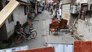 People rest outside houses that are behind barriers blocking the alley in Wuhan, the epicentre of the novel coronavirus outbreak, in China on Wednesday.(Reuters Photo) People rest outside houses that are behind barriers blocking the alley in Wuhan, the epicentre of the novel coronavirus outbreak, in China on Wednesday.(Reuters Photo)