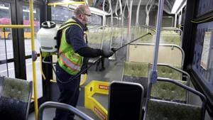 A King County Metro equipment service worker sprays a Virex solution to sanitise buses against the coronavirus in Seattle, Washington, on Thursday.(Reuters Photo) A King County Metro equipment service worker sprays a Virex solution to sanitise buses against the coronavirus in Seattle, Washington, on Thursday.(Reuters Photo)