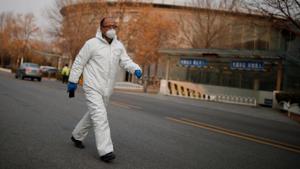 A worker wearing a protective suit walks outside an office building in Beijing as the country is hit by an outbreak of the novel coronavirus, China on March 6, 2020.(Reuters Photo) A worker wearing a protective suit walks outside an office building in Beijing as the country is hit by an outbreak of the novel coronavirus, China on March 6, 2020.(Reuters Photo)
