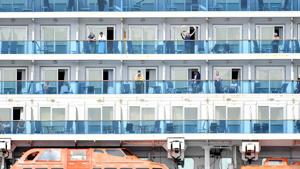 A woman waves as others look out from aboard the Grand Princess cruise ship, operated by Princess Cruises, as it maintains a holding pattern about 25 miles off the coast of San Francisco, California on March 8, 2020.(AFP photo) A woman waves as others look out from aboard the Grand Princess cruise ship, operated by Princess Cruises, as it maintains a holding pattern about 25 miles off the coast of San Francisco, California on March 8, 2020.(AFP photo)
