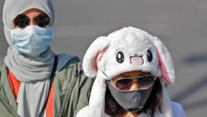 Tourists wearing protective masks walk in a street following an outbreak of the coronavirus disease, in New Delhi, on Monday.(Reuters Photo) Tourists wearing protective masks walk in a street following an outbreak of the coronavirus disease, in New Delhi, on Monday.(Reuters Photo)