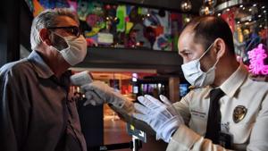 A tourist gets his temperature checked by a security guard, amid concerns over the spread of the COVID-19 coronavirus, in a shopping mall in Bangkok on March 11, 2020.(AFP) A tourist gets his temperature checked by a security guard, amid concerns over the spread of the COVID-19 coronavirus, in a shopping mall in Bangkok on March 11, 2020.(AFP)