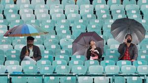 General view of fans using umbrellas inside the stadium as the start of the match is delayed by rain.(REUTERS) General view of fans using umbrellas inside the stadium as the start of the match is delayed by rain.(REUTERS)