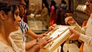 A salesman shows a gold necklace to customers at a jewellery showroom in Ahmedabad, India, in October 2019.(Reuters File Photo) A salesman shows a gold necklace to customers at a jewellery showroom in Ahmedabad, India, in October 2019.(Reuters File Photo)