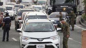 Army troopers use a thermal scanner to check the temperatures of people entering the metropolis at a checkpoint on the outskirts of Quezon city, Philippines.(AP) Army troopers use a thermal scanner to check the temperatures of people entering the metropolis at a checkpoint on the outskirts of Quezon city, Philippines.(AP)
