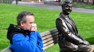 A man blows his nose as he sits next to a statue of Mr Bean in Leicester Square as the number of coronavirus cases grow around the world, in London, Britain, March 17, 2020.(REUTERS) A man blows his nose as he sits next to a statue of Mr Bean in Leicester Square as the number of coronavirus cases grow around the world, in London, Britain, March 17, 2020.(REUTERS)