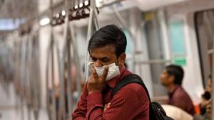 A commuter uses his handkerchief to cover his face as he travels in a metro amid coronavirus fears, in New Delhi on March 17.(Reuters Photo) A commuter uses his handkerchief to cover his face as he travels in a metro amid coronavirus fears, in New Delhi on March 17.(Reuters Photo)