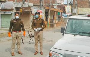 Police personnel stand guard near a sealed road in Nayagaon that leads to the house of 65-year-old man who was tested positive for Covid-19 on Monday.(Anil Dayal) Police personnel stand guard near a sealed road in Nayagaon that leads to the house of 65-year-old man who was tested positive for Covid-19 on Monday.(Anil Dayal)