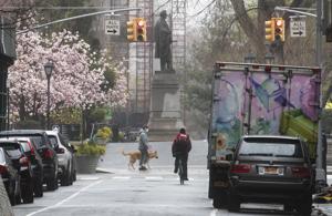 A cyclist and a dog walker are seen along West 16th Street near Union Square, Sunday, March 29, 2020, in New York.(AP) A cyclist and a dog walker are seen along West 16th Street near Union Square, Sunday, March 29, 2020, in New York.(AP)