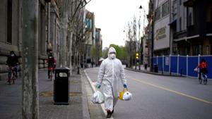 A man wearing a hazmat suit walks on a street in Wuhan, Hubei province of China amid coronavirus outbreak.(REUTERS) A man wearing a hazmat suit walks on a street in Wuhan, Hubei province of China amid coronavirus outbreak.(REUTERS)