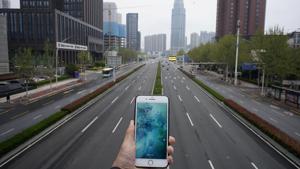 A mobile phone showing the time at noon, is displayed for a photo in front of an almost empty road with low traffic, during the coronavirus disease (COVID-19) outbreak, in Wuhan.(REUTERS) A mobile phone showing the time at noon, is displayed for a photo in front of an almost empty road with low traffic, during the coronavirus disease (COVID-19) outbreak, in Wuhan.(REUTERS)