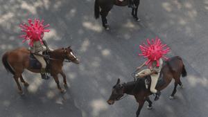 Policeman wearing virus themed helmets ride on horses during an awareness rally aimed at preventing the spread of new coronavirus in Hyderabad.(AP) Policeman wearing virus themed helmets ride on horses during an awareness rally aimed at preventing the spread of new coronavirus in Hyderabad.(AP)