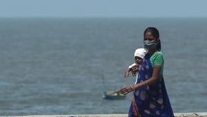 A woman wearing a facemask walks along a promenade carrying a child during a government-imposed nationwide lockdown as a preventive measure against the COVID-19 coronavirus, in Mumbai, India on April 9, 2020.(AFP) A woman wearing a facemask walks along a promenade carrying a child during a government-imposed nationwide lockdown as a preventive measure against the COVID-19 coronavirus, in Mumbai, India on April 9, 2020.(AFP)