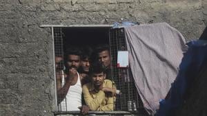 Migrant workers from other states look through the window of a room in Dharavi, one of Asia's largest slums, during lockdown to prevent the spread of the new coronavirus in Mumbai.(AP) Migrant workers from other states look through the window of a room in Dharavi, one of Asia's largest slums, during lockdown to prevent the spread of the new coronavirus in Mumbai.(AP)