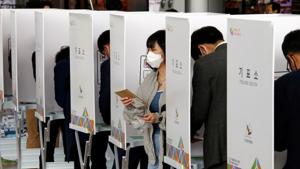 A woman wearing a mask to prevent contracting the coronavirus leaves a voting booth to cast her absentee ballot for the parliamentary election at a polling station in Seoul, South Korea on April 10, 2020.(Reuters photo) A woman wearing a mask to prevent contracting the coronavirus leaves a voting booth to cast her absentee ballot for the parliamentary election at a polling station in Seoul, South Korea on April 10, 2020.(Reuters photo)