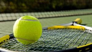A tennis racket and new tennis ball on a freshly painted tennis court A tennis racket and new tennis ball on a freshly painted tennis court