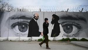 A man wearing a facemask as a precautionary measure against the COVID-19 novel coronavirus walk past a wall painted with images of US Special Representative for Afghanistan Reconciliation Zalmay Khalilzad (L) and Taliban co-founder Mullah Abdul Ghani Baradar (R), in Kabul April 5, 2020.(AFP) A man wearing a facemask as a precautionary measure against the COVID-19 novel coronavirus walk past a wall painted with images of US Special Representative for Afghanistan Reconciliation Zalmay Khalilzad (L) and Taliban co-founder Mullah Abdul Ghani Baradar (R), in Kabul April 5, 2020.(AFP)