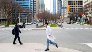 A health care worker runs across University Avenue from Mount Sinai Hospital to Toronto General Hospital as the number of the coronavirus disease (COVID-19) cases continues to grow in Toronto, Ontario.(REUTERS) A health care worker runs across University Avenue from Mount Sinai Hospital to Toronto General Hospital as the number of the coronavirus disease (COVID-19) cases continues to grow in Toronto, Ontario.(REUTERS)