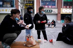 People with face masks eat outside a McDonald's restaurant in Wuhan, Hubei province of China.(Reuters Photo) People with face masks eat outside a McDonald's restaurant in Wuhan, Hubei province of China.(Reuters Photo)