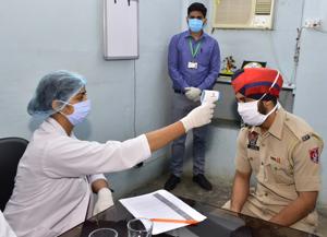 Doctors checking the body temperature of a Punjab Police personnel during a medical check-up camp during lockdown to check the spread of coronavirus at Police line in Amritsar on Wednesday.(HT PHOTO) Doctors checking the body temperature of a Punjab Police personnel during a medical check-up camp during lockdown to check the spread of coronavirus at Police line in Amritsar on Wednesday.(HT PHOTO)