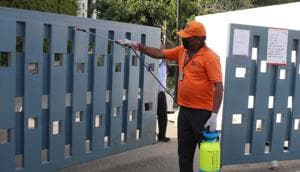 Gurugram, India- April 21: A Grand Arch staff member chemically disinfects the entrance gate during lockdown against coronavirus, at The Grand Arch, Sector 58, in Gurugram, India, on 21 April 2020.(Yogendra Kumar/HT PHOTO)