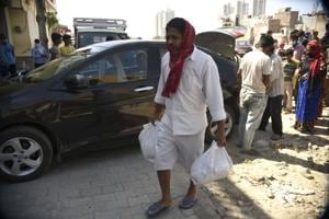 A man with provisions handed to him by a GNEM volunteer in Gurgaon.(Parveen Kumar/HT Photo) A man with provisions handed to him by a GNEM volunteer in Gurgaon.(Parveen Kumar/HT Photo)