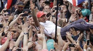 Mercedes driver Lewis Hamilton of Britain celebrates jumping into the crowd, after winning the British Formula One Grand Prix at the Silverstone racetrack.(AP)