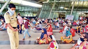 A cop assists people during food distribution at a govt-run shelter home at CIDCO Exhibition Centre in Navi Mumbai on Thursday. A cop assists people during food distribution at a govt-run shelter home at CIDCO Exhibition Centre in Navi Mumbai on Thursday.
