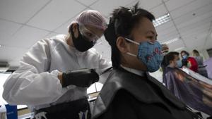 In this Tuesday, April 28, 2020, photo, Pornsupa Hattayong gives haircuts to a medical worker treating COVID-19 patients at Bangkok Metropolitan Administration General Hospital in Bangkok, Thailand. The 43-year-old hairstylist is boosting the morale of frontline medical workers by dispensing free haircuts at Bangkok hospitals since Thailand’s hair salons have been closed for more than a month, to help stop the spread of the coronavirus. (AP Photo/Sakchai Lalit)(AP) In this Tuesday, April 28, 2020, photo, Pornsupa Hattayong gives haircuts to a medical worker treating COVID-19 patients at Bangkok Metropolitan Administration General Hospital in Bangkok, Thailand. The 43-year-old hairstylist is boosting the morale of frontline medical workers by dispensing free haircuts at Bangkok hospitals since Thailand’s hair salons have been closed for more than a month, to help stop the spread of the coronavirus. (AP Photo/Sakchai Lalit)(AP)