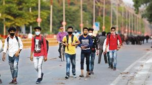 Workers arrive to catch a bus to travel to their home states, in Prayagraj.(AP) Workers arrive to catch a bus to travel to their home states, in Prayagraj.(AP)
