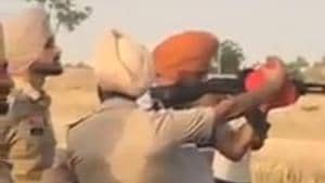 A screengrab of the video showing cops letting Moose Wala fire from assault rifle.(HT PHOTO)