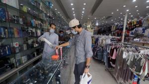 A man wearing a protective face mask buys perfume from a store in Peshawar, after Pakistan started easing Covid-19 lockdown on May 11.(Reuters Photo) A man wearing a protective face mask buys perfume from a store in Peshawar, after Pakistan started easing Covid-19 lockdown on May 11.(Reuters Photo)