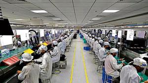 Workers wearing face shields work at an assembly line of mobile phones, after some restrictions were lifted during an extended nationwide lockdown to slow the spread of the coronavirus disease(COVID-19) in Noida(Reuters) Workers wearing face shields work at an assembly line of mobile phones, after some restrictions were lifted during an extended nationwide lockdown to slow the spread of the coronavirus disease(COVID-19) in Noida(Reuters)